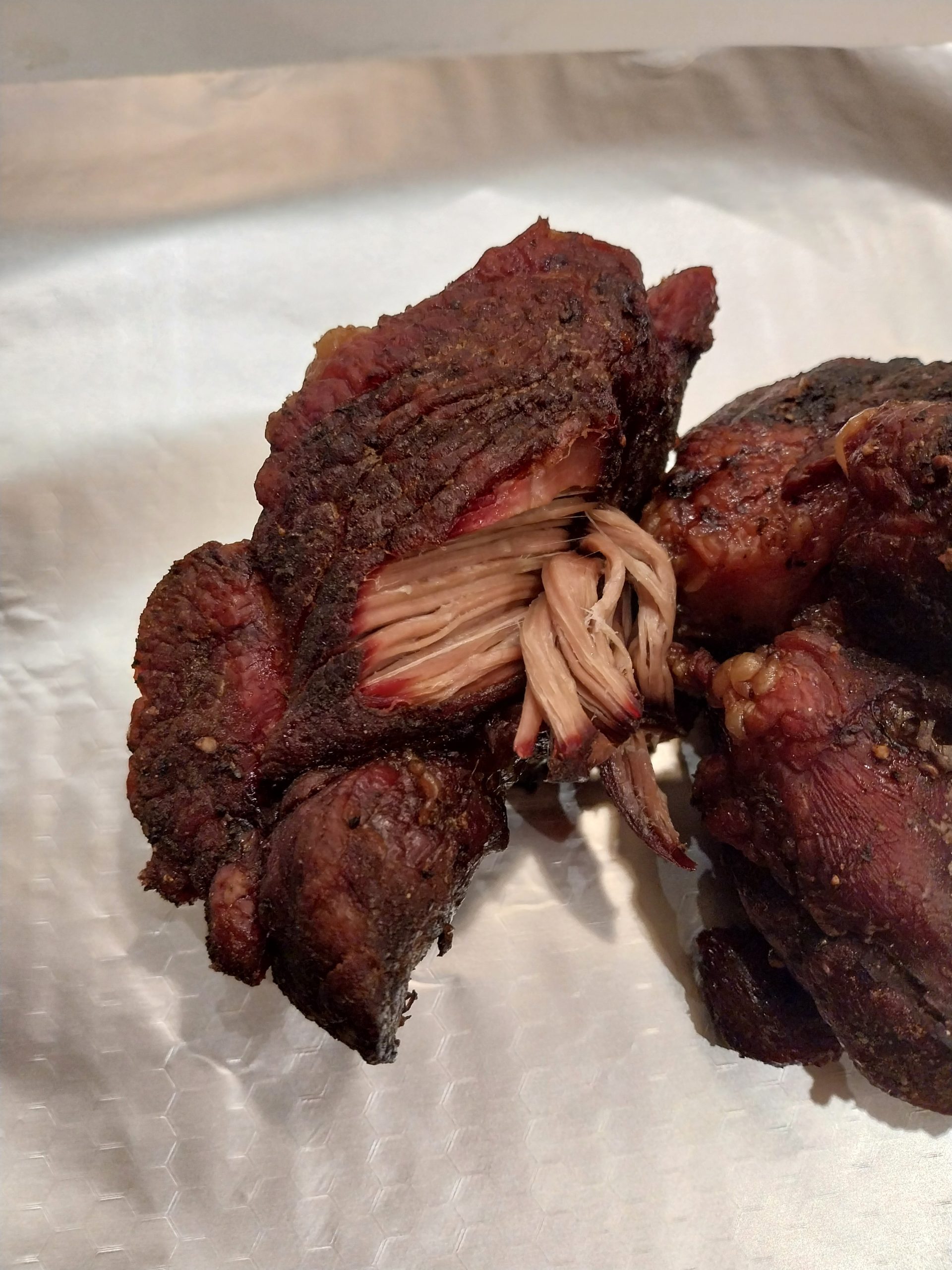 Smaller pork shoulder piece at the 21:50 bedtime check, around 88°C internal — bark set, strands starting to pull but the cook isn't quite there yet. The moment that triggered the overnight faux-cambro.