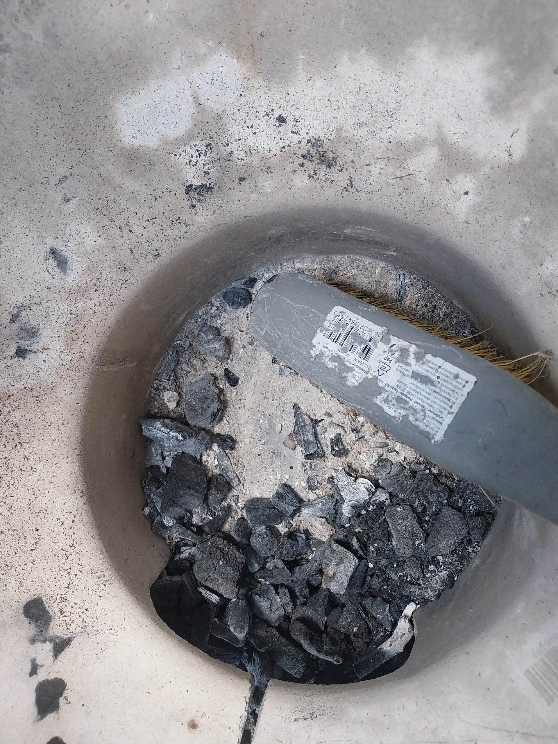 BGE Large firebox interior post-cleanout, ash basket visible — preparation for next cook