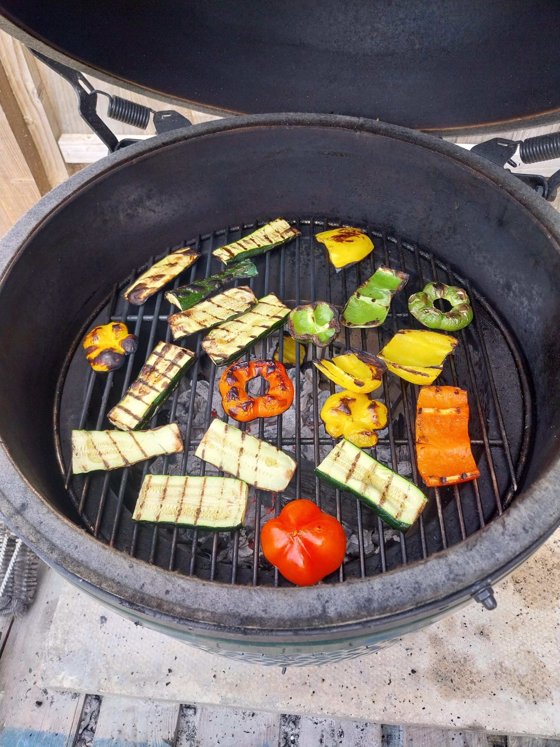 Charred peppers, courgettes and a tomato direct on the BGE Large's grid after the deflector pull