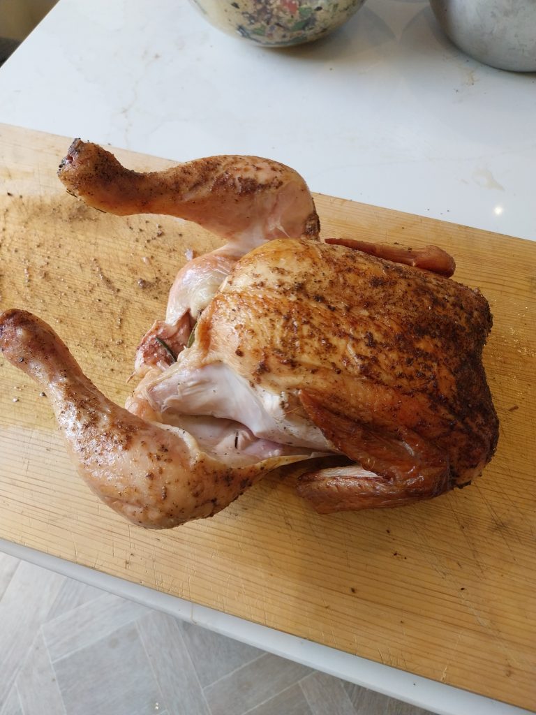 Whole roast chicken with crispy skin on a Broil King vertical roaster, finished on the BGE Large with a 220°C reverse-finish