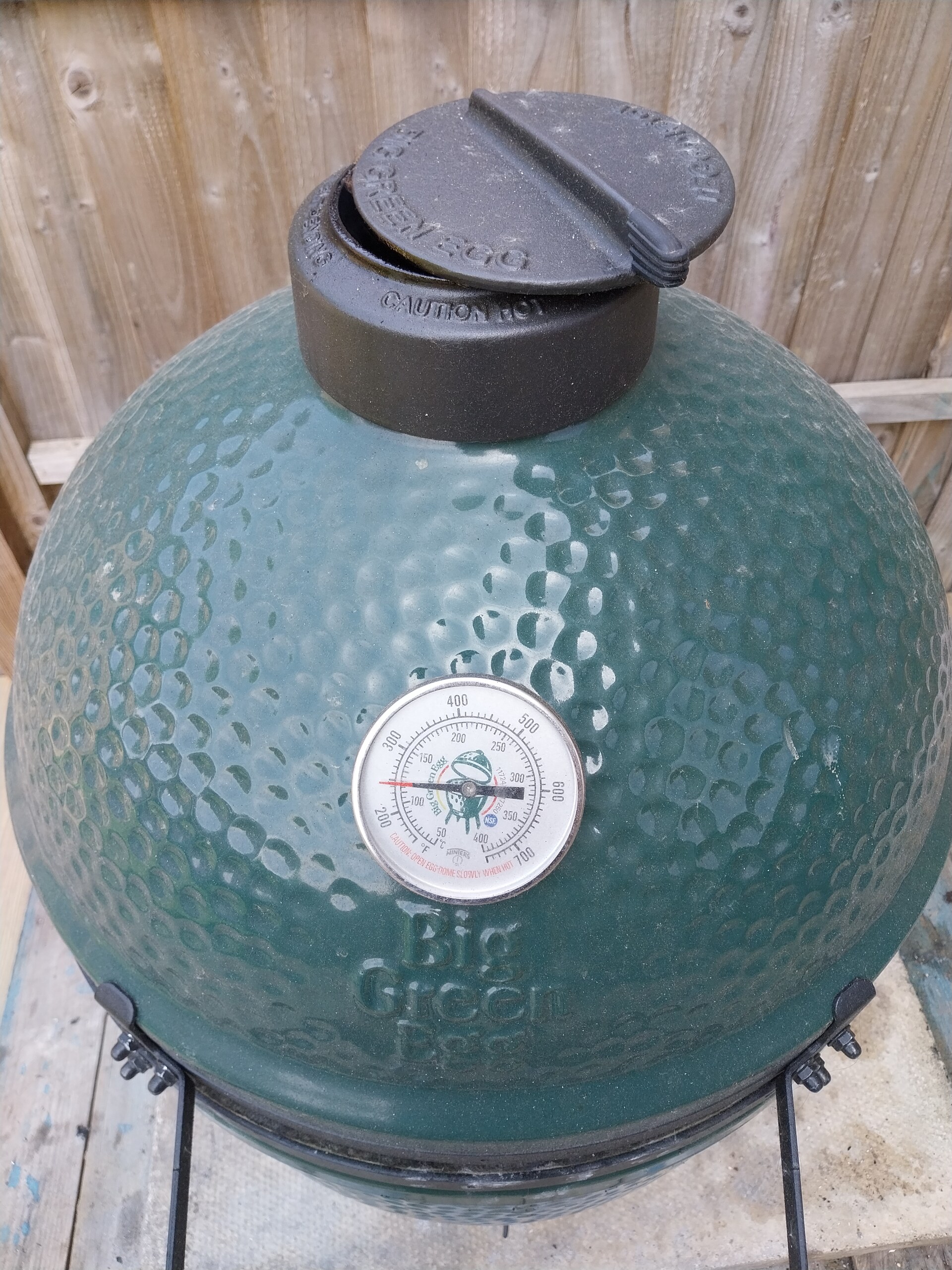 Dome thermometer on a Big Green Egg Large reading 115°C — close-up showing stable dial position mid-cook