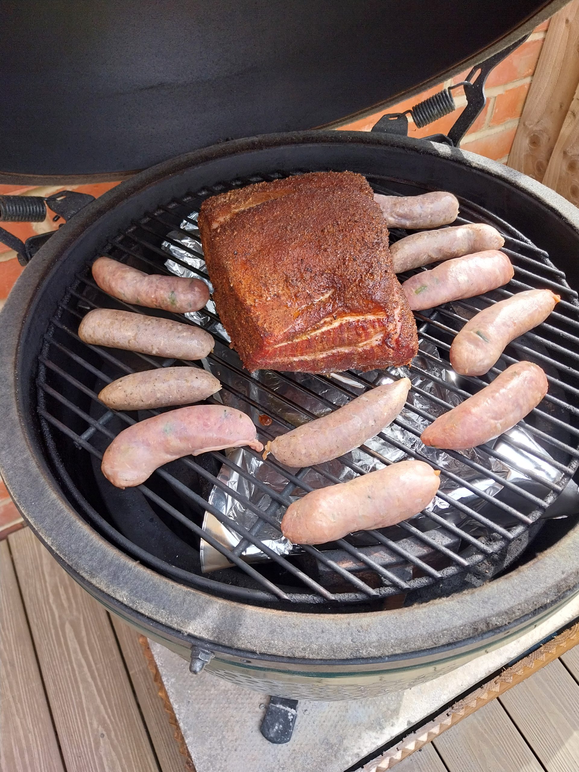 Bone-in pork loin on the BGE Large grid alongside smoked sausages, 140°C dome indirect over two oak chunks under the ConvEGGtor — second cook, 7 June 2026