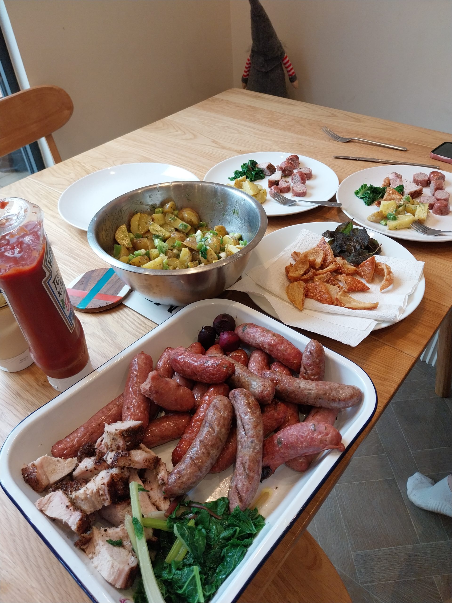 Smoked sausages plated as part of the 7 June multi-protein Sunday spread on the Big Green Egg Large — alongside bone-in pork loin, rainbow chard, kale, and sage.