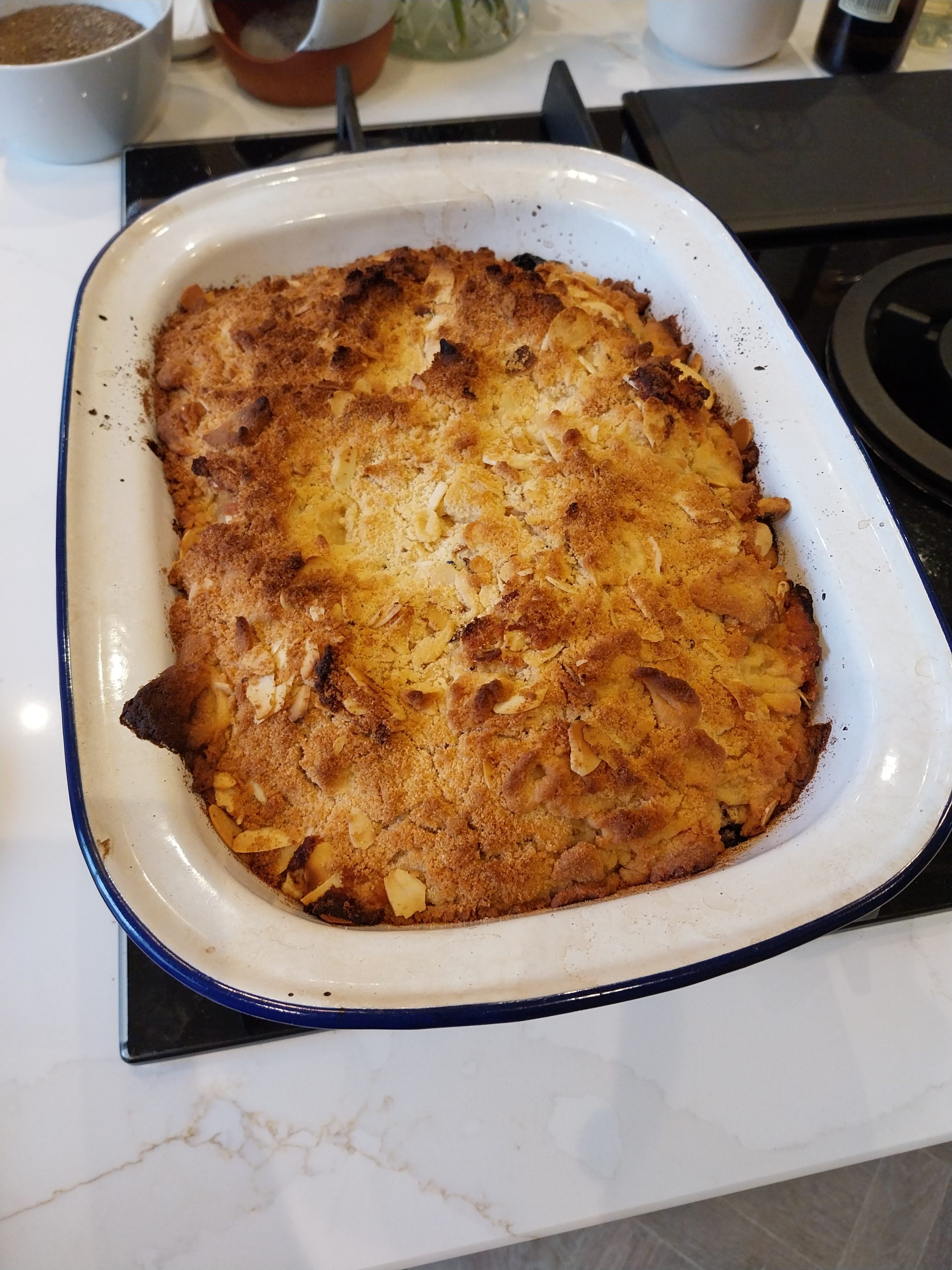 Apple and summer berry crumble in a white ceramic baking dish with blue trim, golden topping with toasted almonds visible — cooked on the BGE Large on 7 June 2026