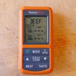 The ThermoPro TP20 receiver on a scratched wooden board, set to its beef preset, with neither probe channel showing a reading.
