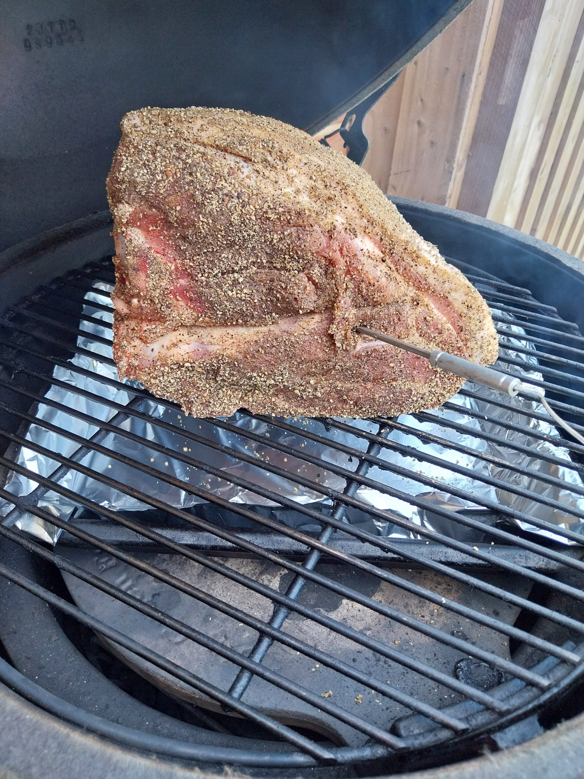 The bone-in pork shoulder going on the BGE Large grate fat-cap up at the start of cook two, three small oak chunks in with the lump charcoal, ConvEGGtor in for indirect cooking at around 115°C dome.