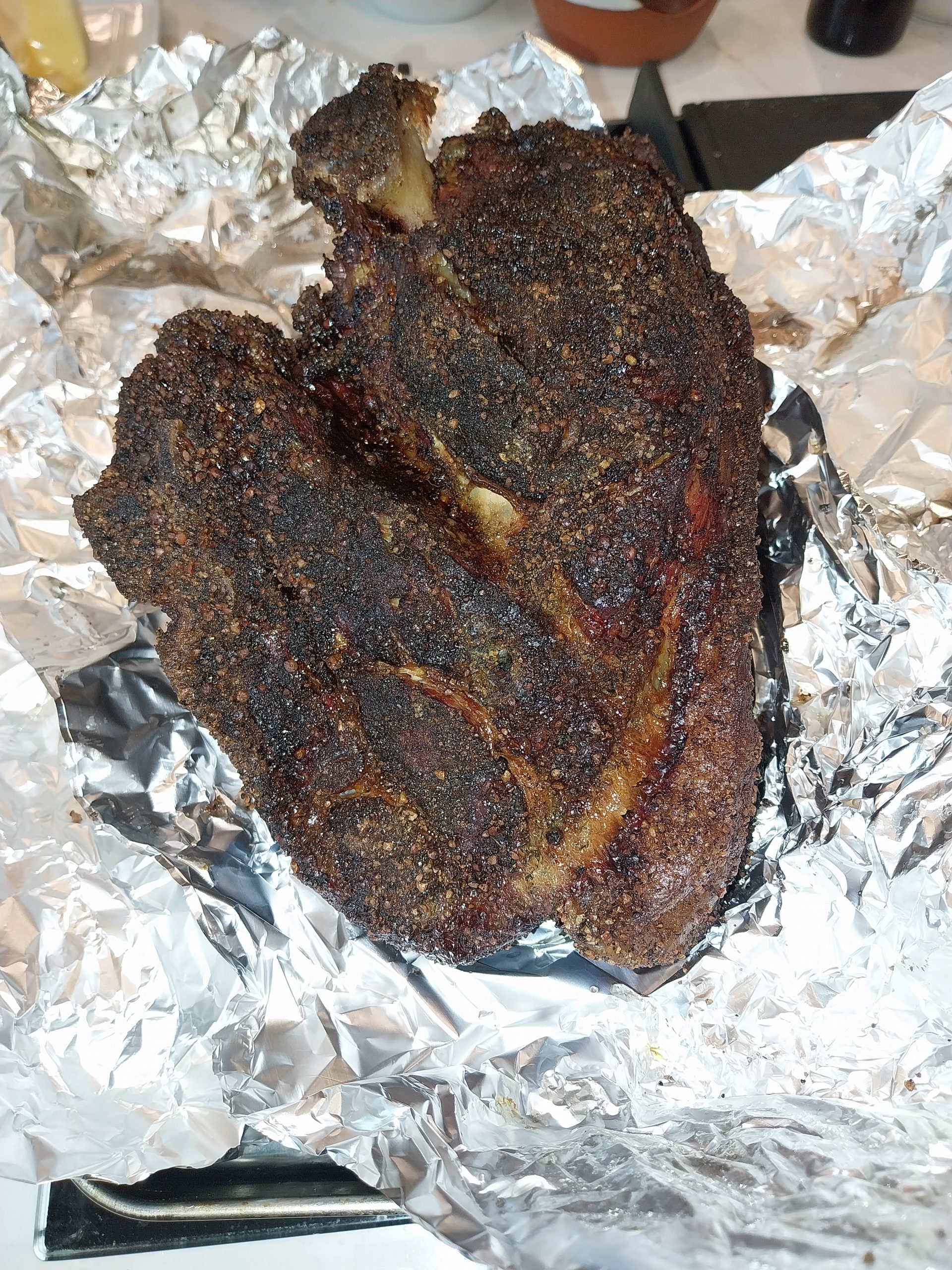 The morning unwrap at around 07:55 BST — the bone-in pork shoulder pulled from the overnight faux-cambro, fat cap rendered through, residual heat around 50°C, ready to shred cleanly across the whole joint.