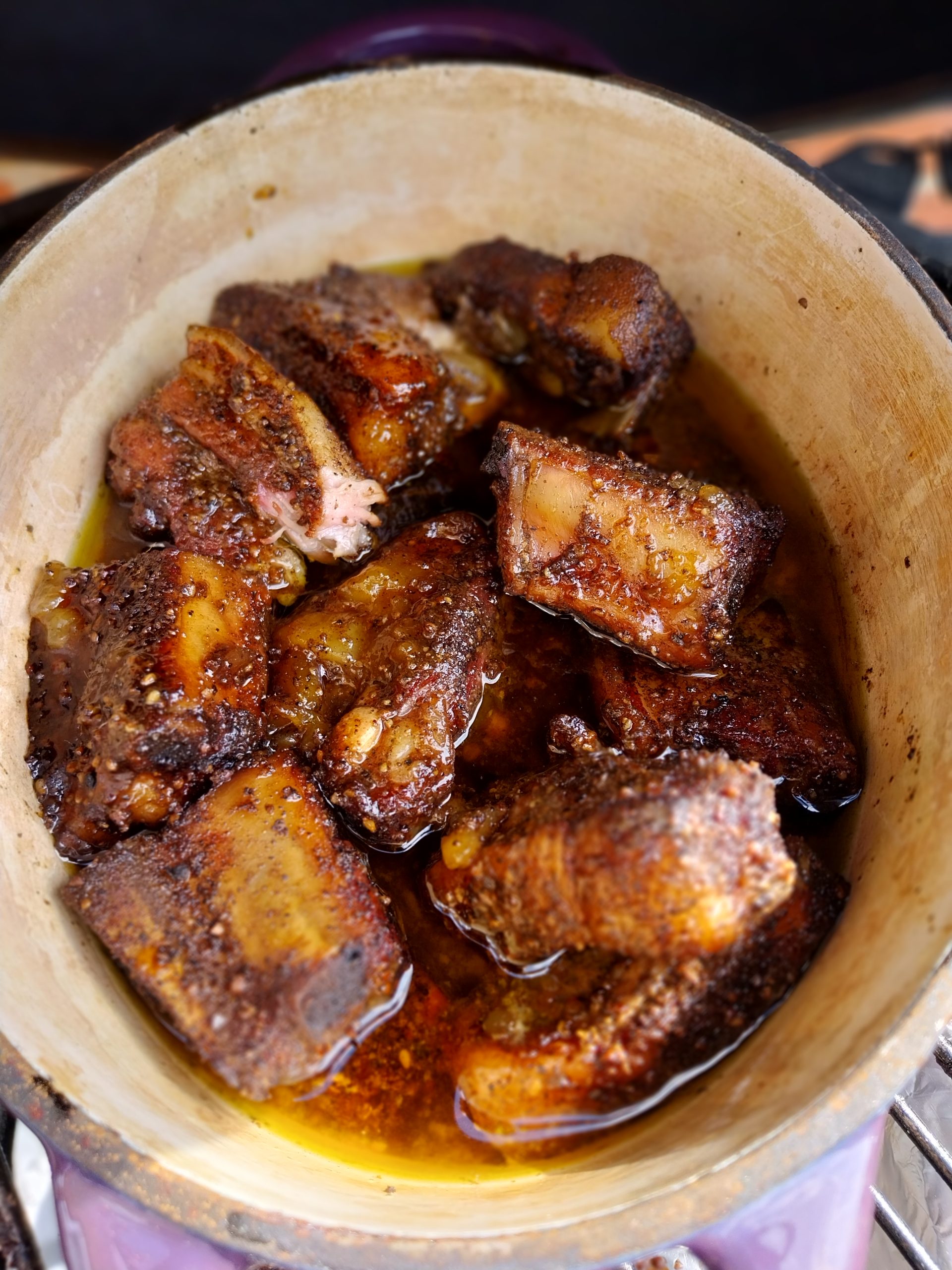 Close-up on the finished glaze — Sharwood's mango chutney reduced with 150 g butter and a splash of cider vinegar, dark and viscous, ready to hot-hold on the kamado.