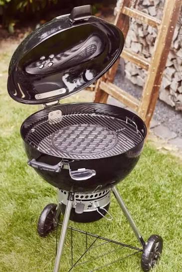 Weber Master-Touch GBS 57cm — alternate angle showing the vented lid, side handles, one-touch damper wheel and rolled bowl rim.