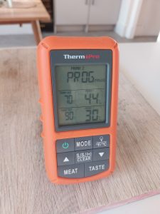 The ThermoPro TP20 receiver on a table, in Program mode with both probes reading