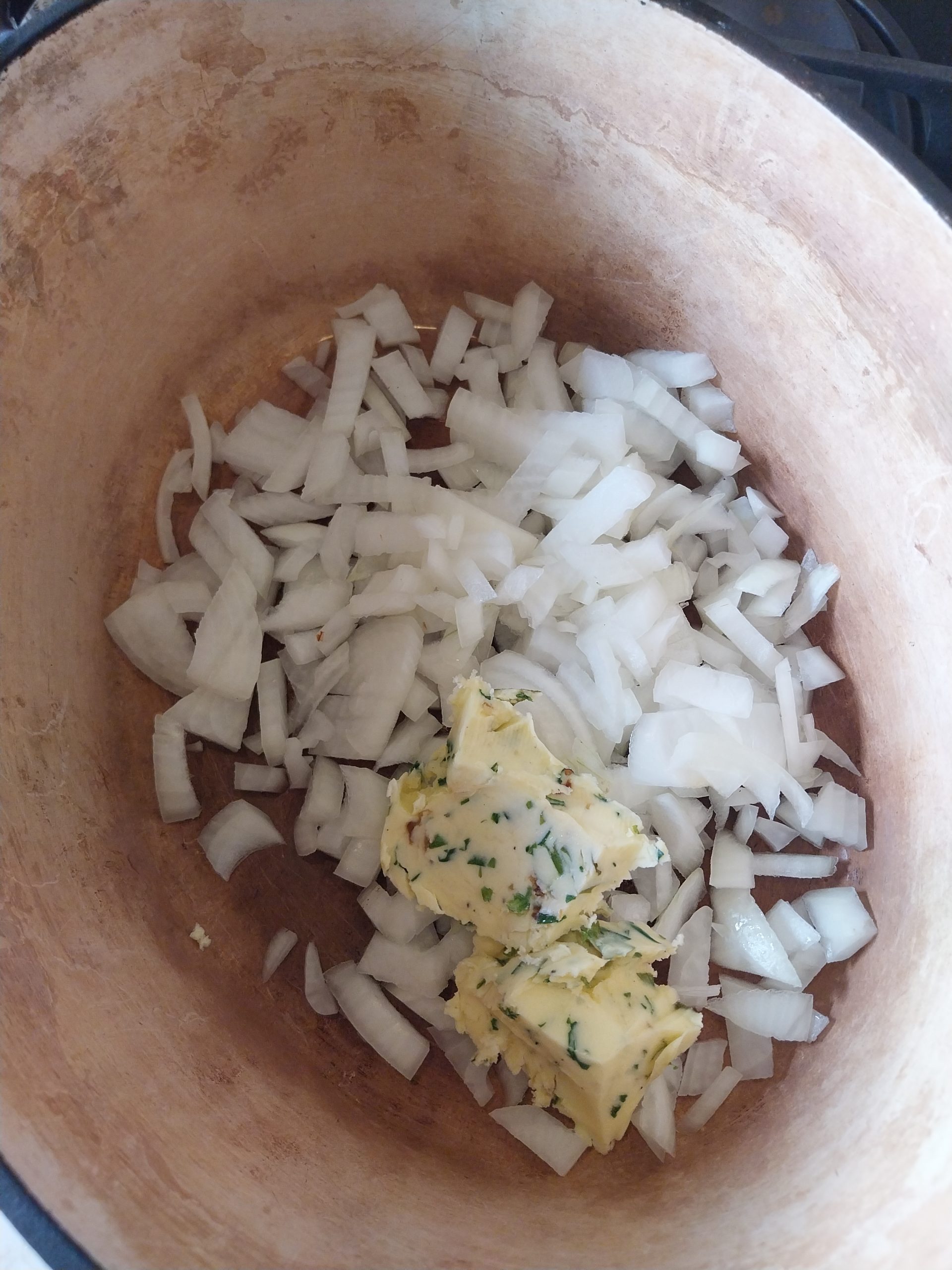 Chopped onion and confit garlic butter in a cast iron pot, the start of the bacon jam