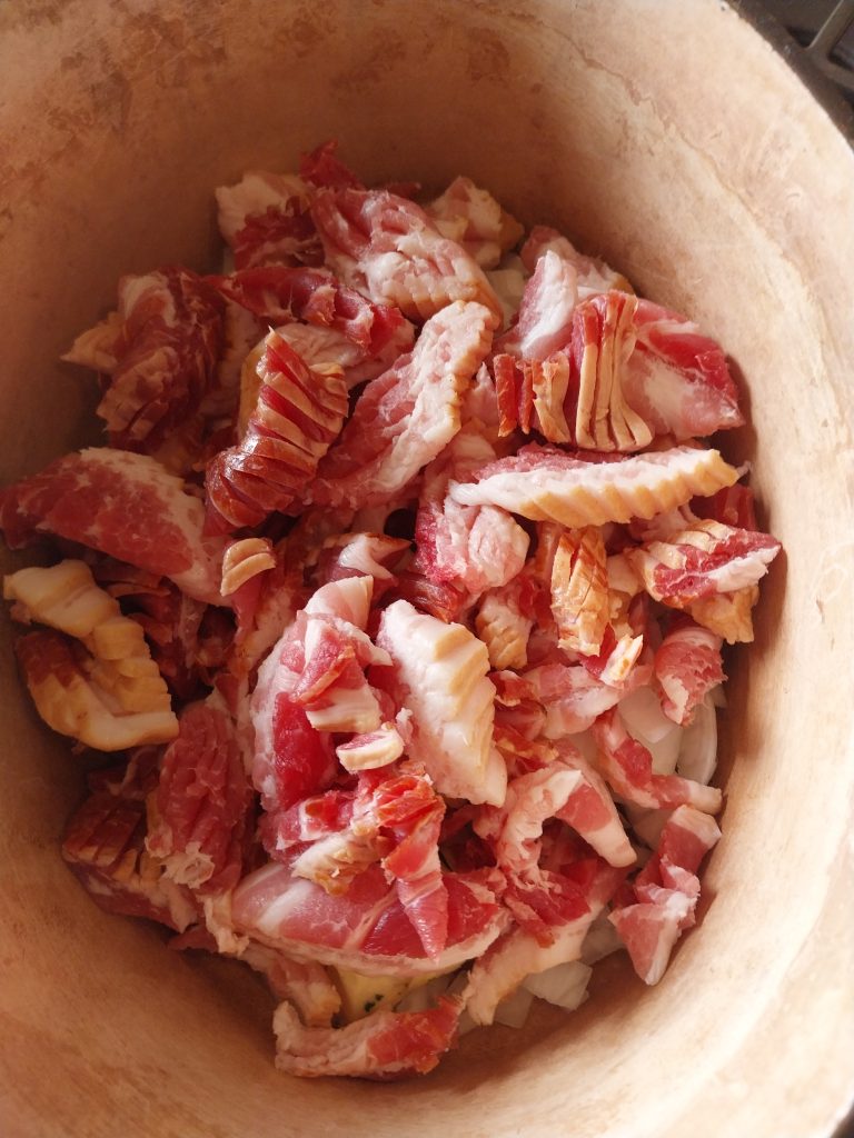 Smoked streaky bacon snipped into the pot on top of the onion for the bacon jam