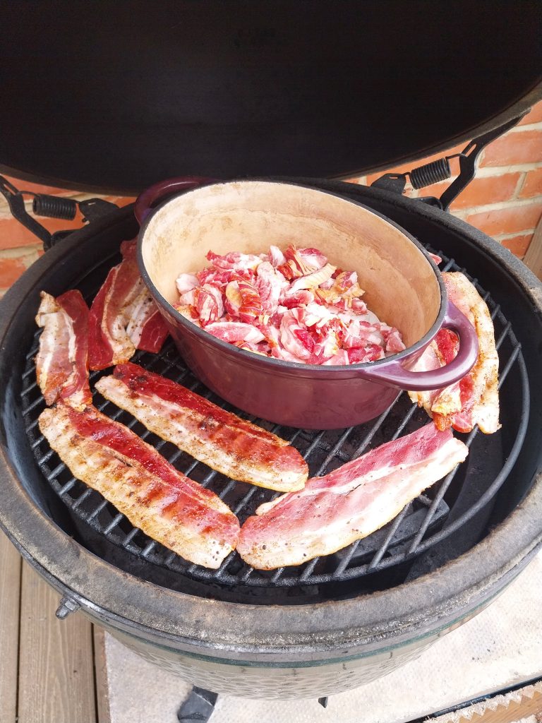Candied bacon rashers on the kamado grate around a cast iron pot of bacon jam