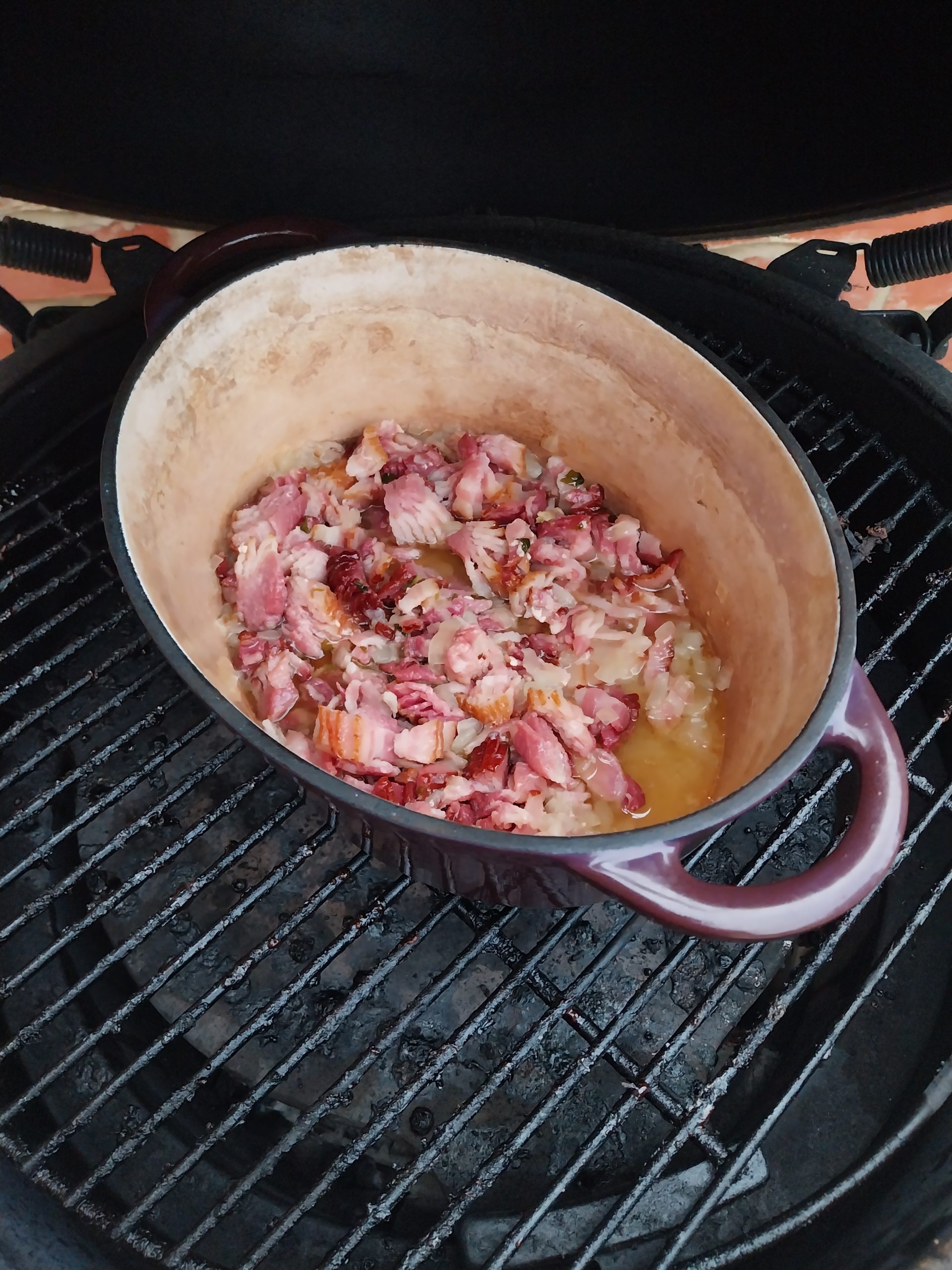 Bacon jam in the pot on the kamado grate, with the fat rendering out