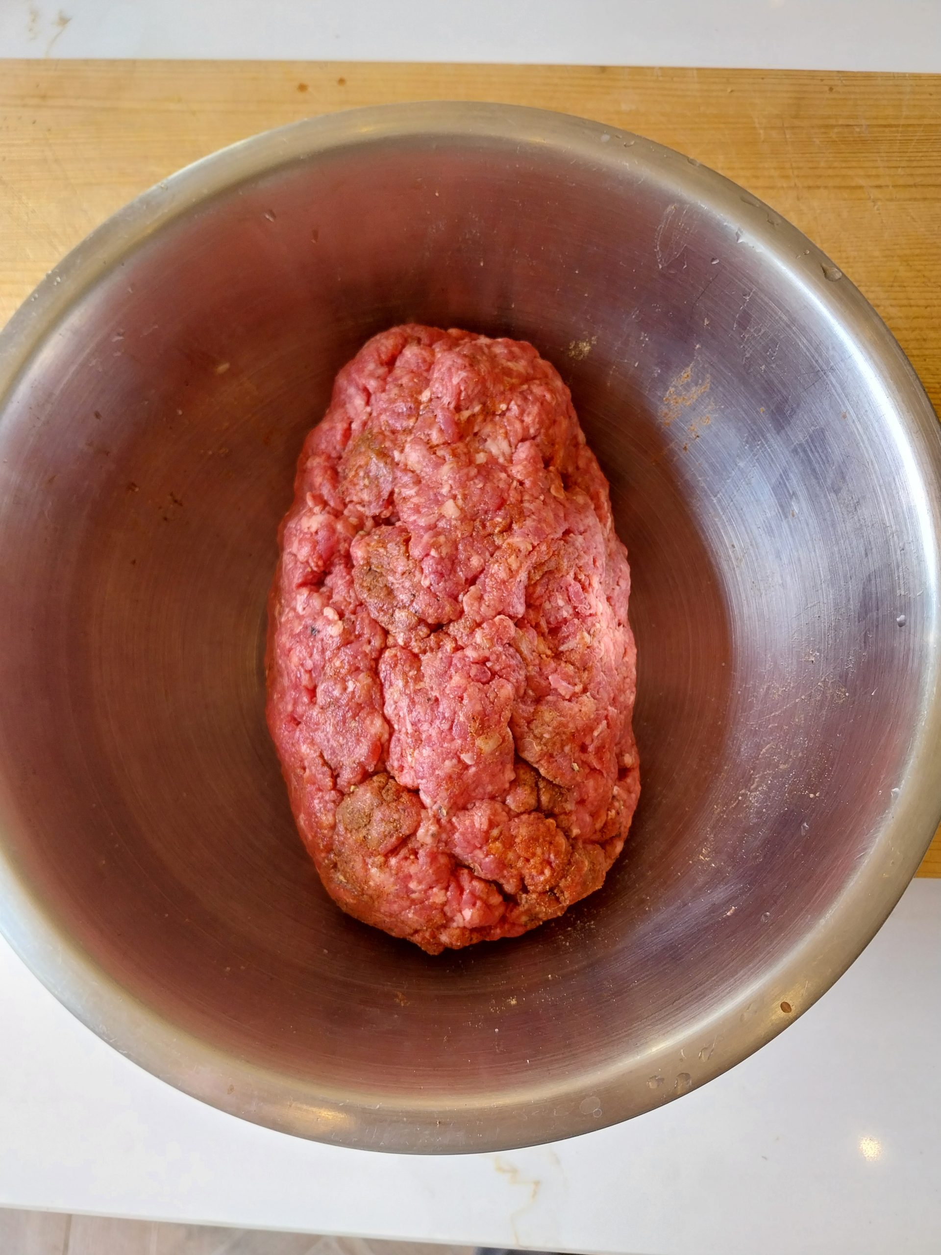 500g of seasoned beef mince shaped into a rugby ball in a stainless steel bowl before going on the barbecue.