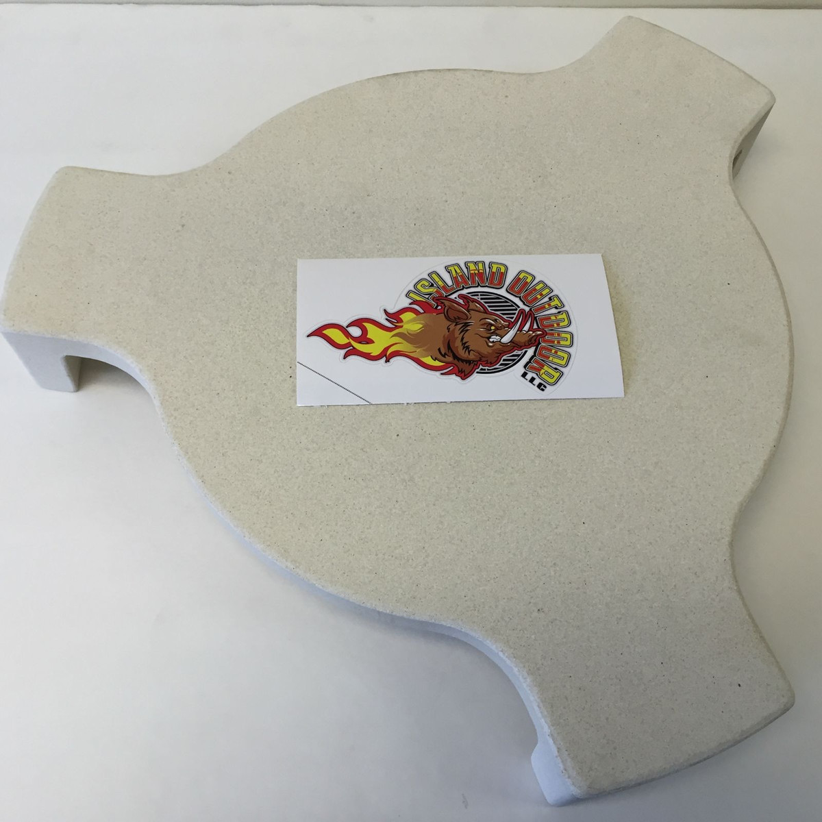 LavaLock Plate Setter — a pale ceramic deflector disc, shaped rim, photographed on a white surface with a LavaLock sticker on its face. Image: LavaLock.