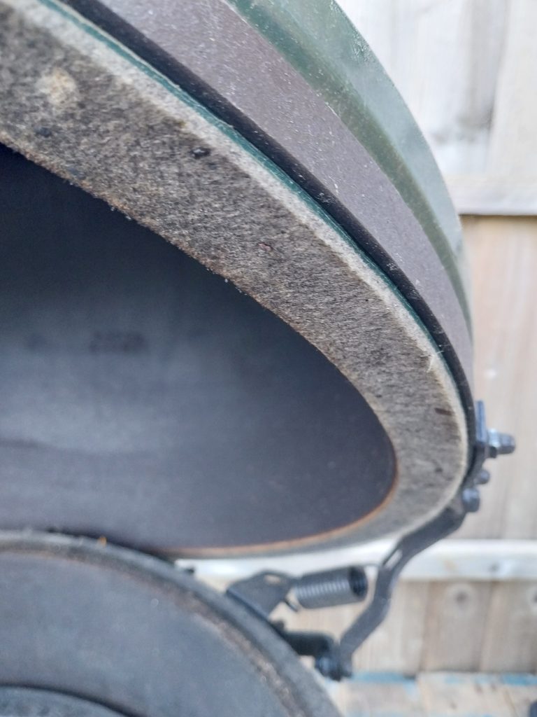 The felt gasket round the rim of the Big Green Egg Large's lid, with the lid raised