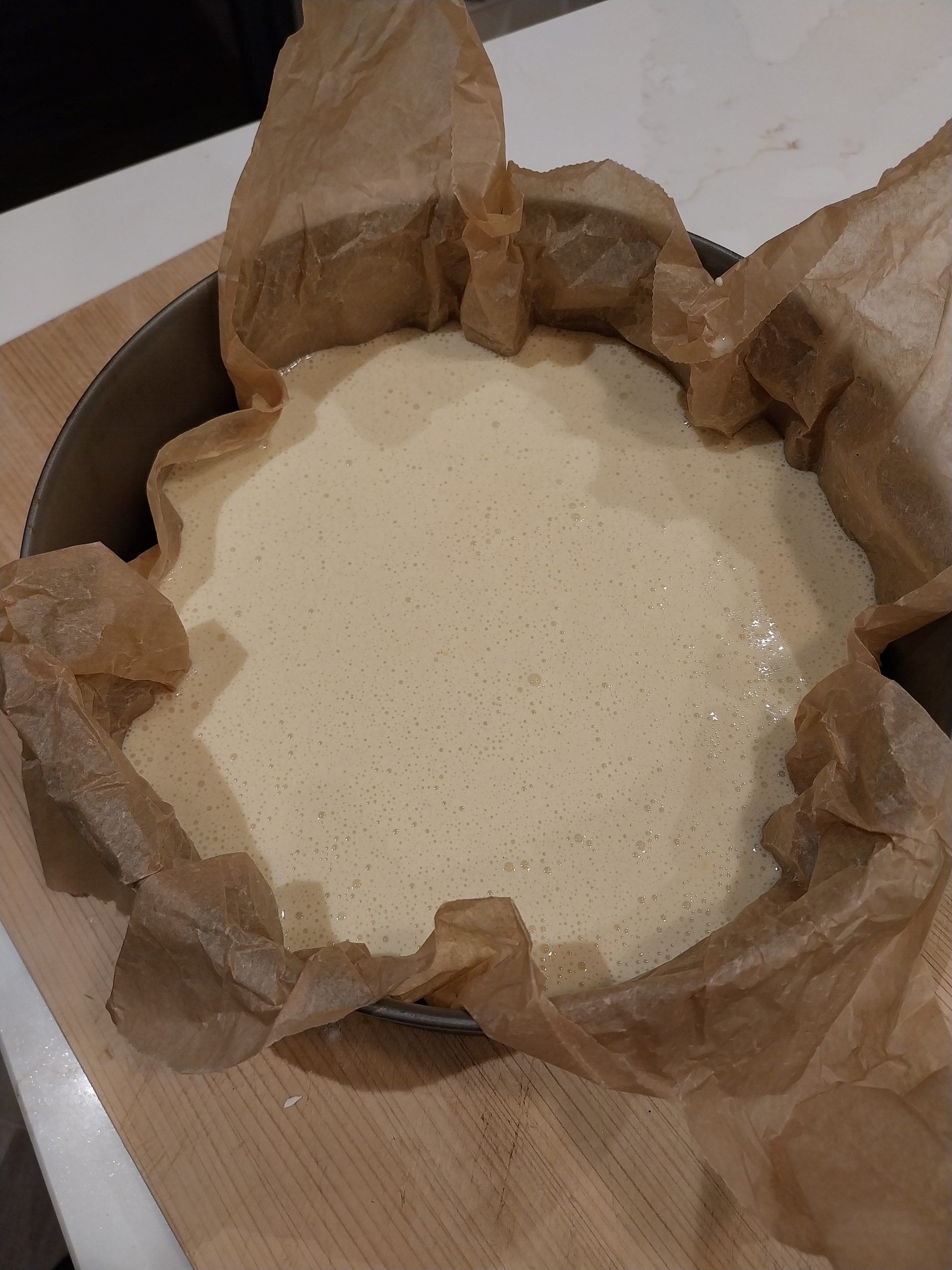 The cheesecake mixture poured into a tin lined with baking parchment