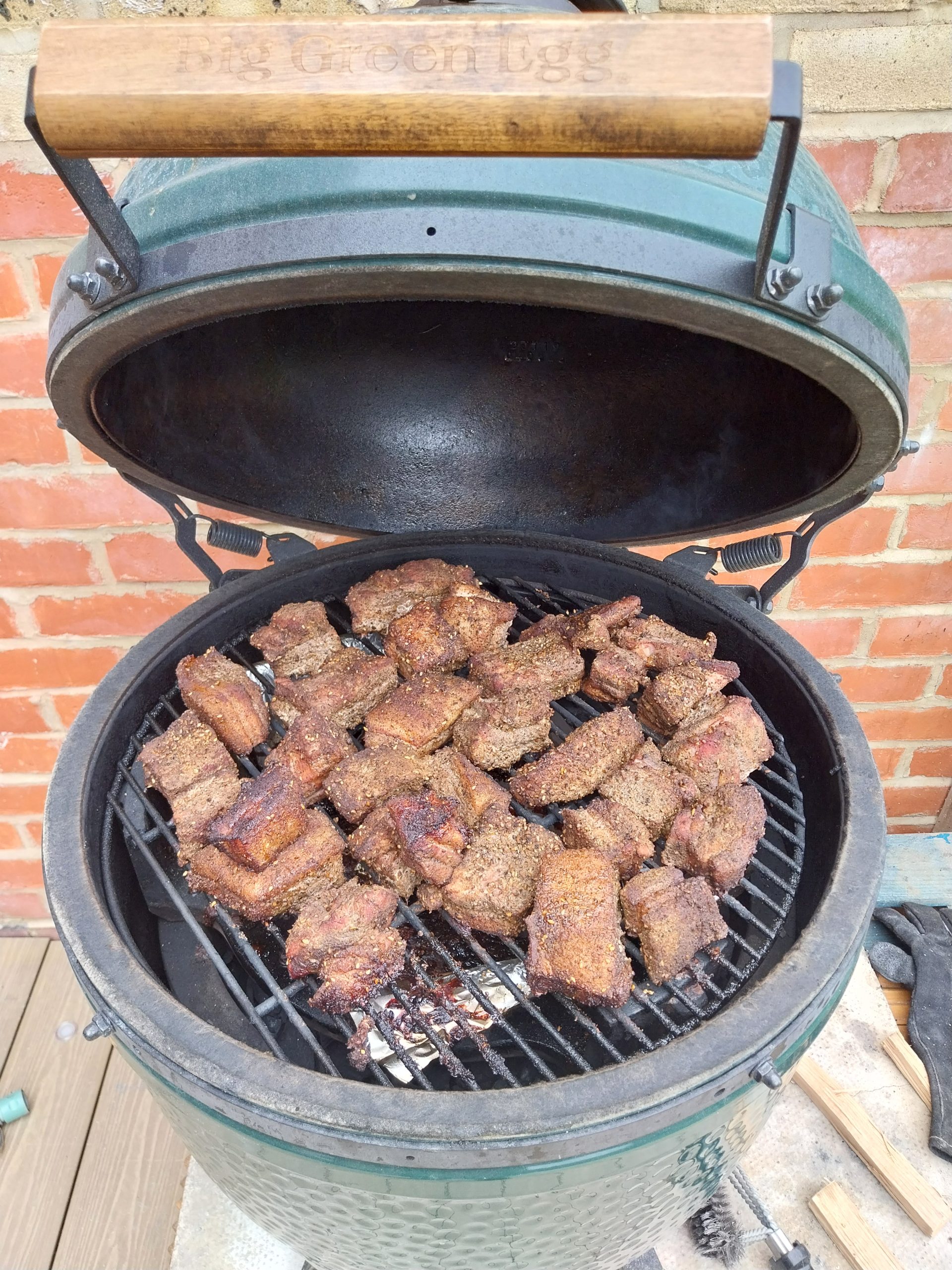 The pork belly chunks browned on the Big Green Egg grate at the end of the first stage, lid open