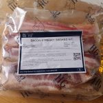 A vacuum pack of HG Walter smoked streaky bacon on a wooden worktop, label reading BACON STREAKY SMOKED H/C.