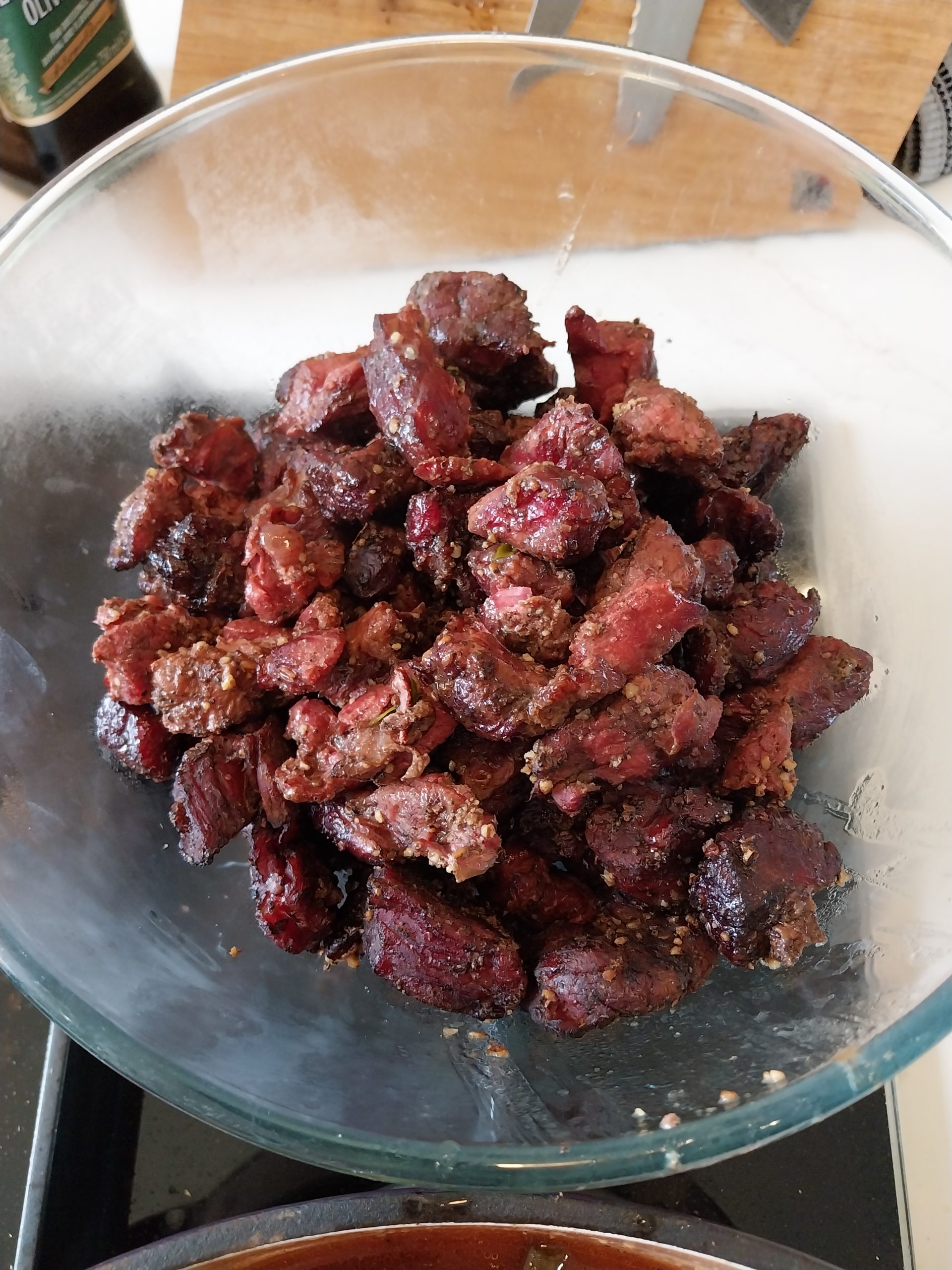 Braised beef chuck cubes in a glass bowl after coming out of the IPA liquor