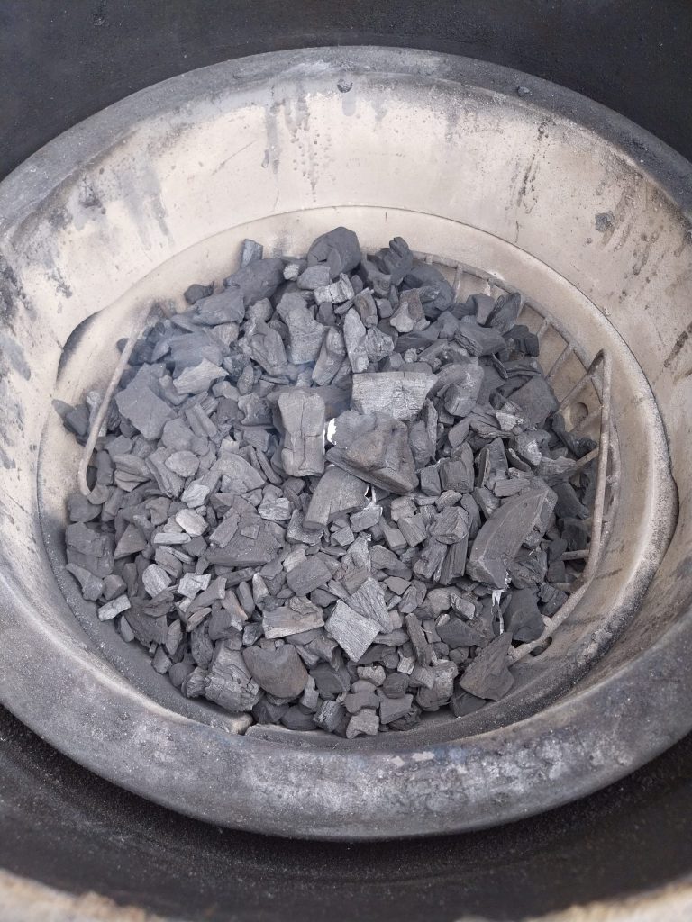Small lumps of Diall lumpwood charcoal in the Big Green Egg's fire basket, about 15 minutes after lighting and barely caught