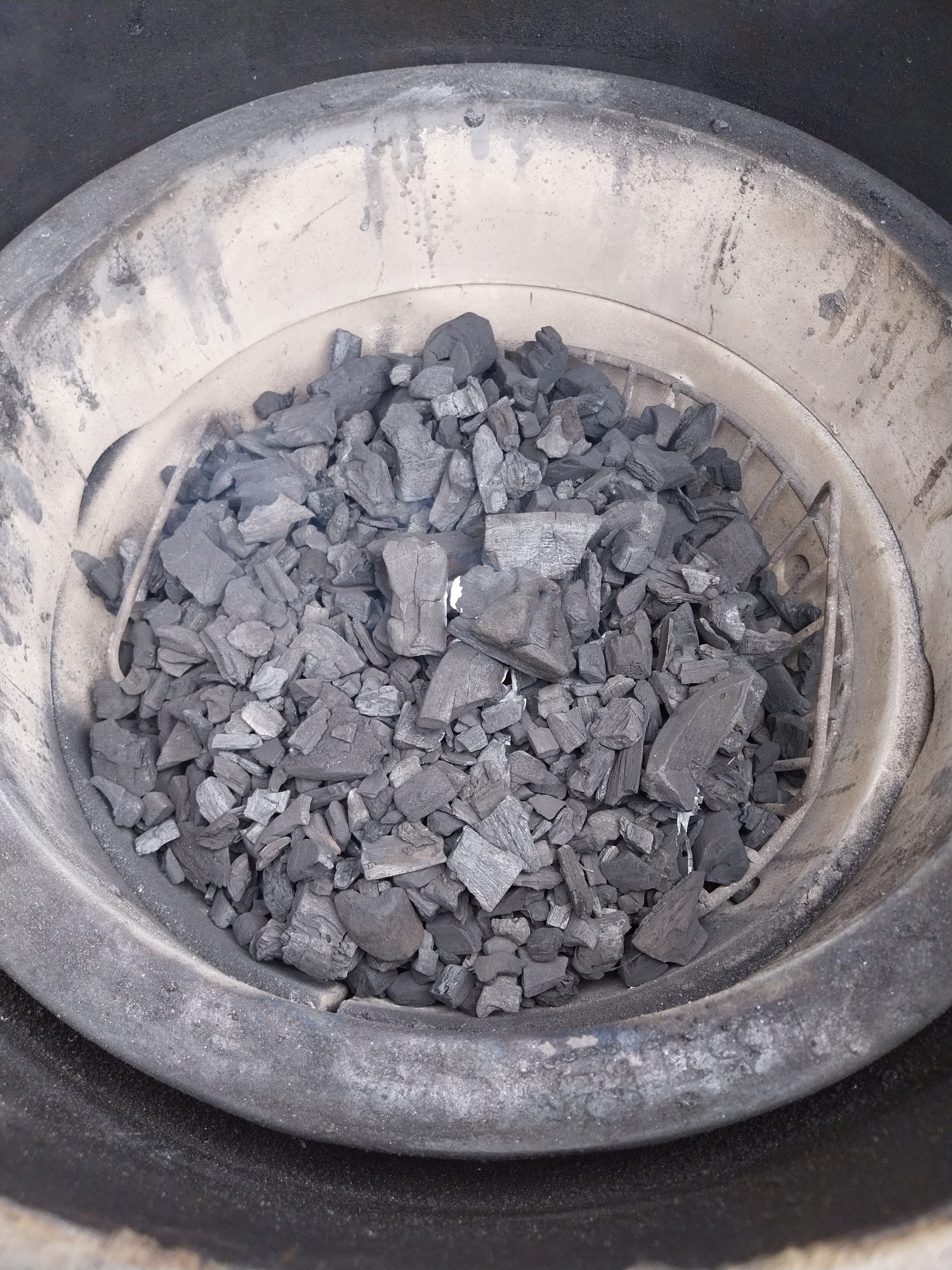 Small lumps of Diall lumpwood charcoal in the Big Green Egg's fire basket, about 15 minutes after lighting and barely caught