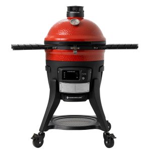 The Konnected Joe from the front: a red ceramic kamado with a thermometer in the dome, a control panel under the bowl, two side shelves and a black cart on wheels.