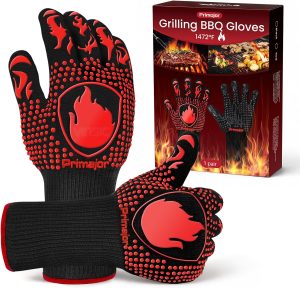 A pair of black knitted gloves with a red silicone flame pattern, in front of their red Grilling BBQ Gloves box. Image: Amazon UK.